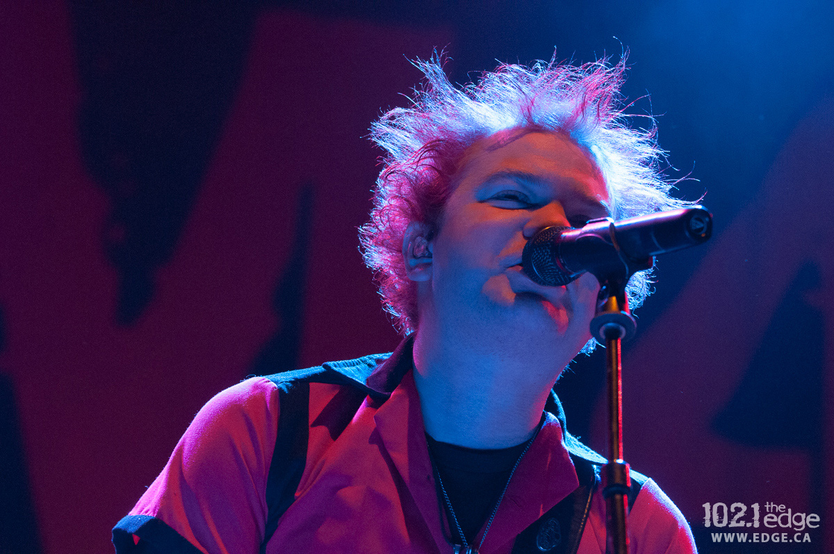 Closeup of Deryck Whibley singing into a microphone on stage.