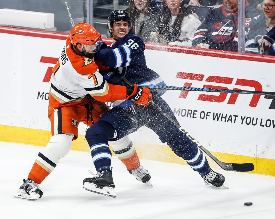 Winnipeg Jets' Morgan Barron (36) and Anaheim Ducks' Radko Gudas (7) jostle for a loose puck during second period NHL action in Winnipeg, Thursday, Jan. 2, 2025. THE CANADIAN PRESS/John Woods