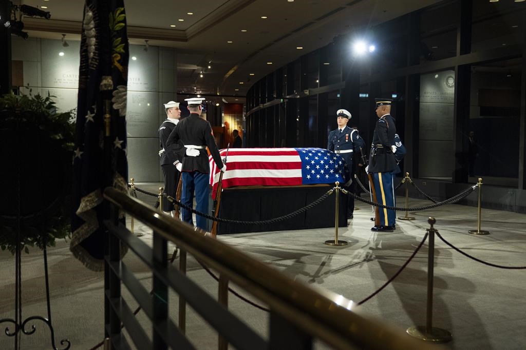 The joint services military honor guard stand around the casket of former President Jimmy Carter as he lies in repose at the Jimmy Carter Presidential Library and Museum in Atlanta, Tuesday, Jan. 7, 2025. Carter died Dec. 29 at the age of 100. (AP Photo/Alex Brandon, Pool)