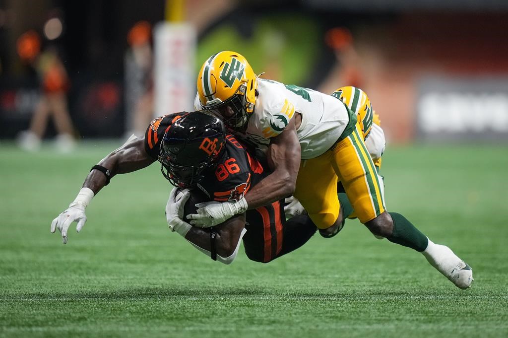 B.C. Lions' Jevon Cottoy (86) is tackled by Edmonton Elks' Elliott Brown after making a reception during the second half of a CFL football game, in Vancouver, on Thursday, June 27, 2024.