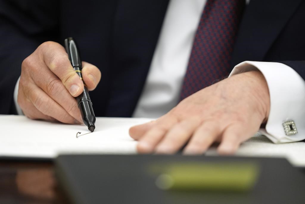 President Donald Trump signs executive orders in the Oval Office of the White House, Monday, Jan. 20, 2025, in Washington.