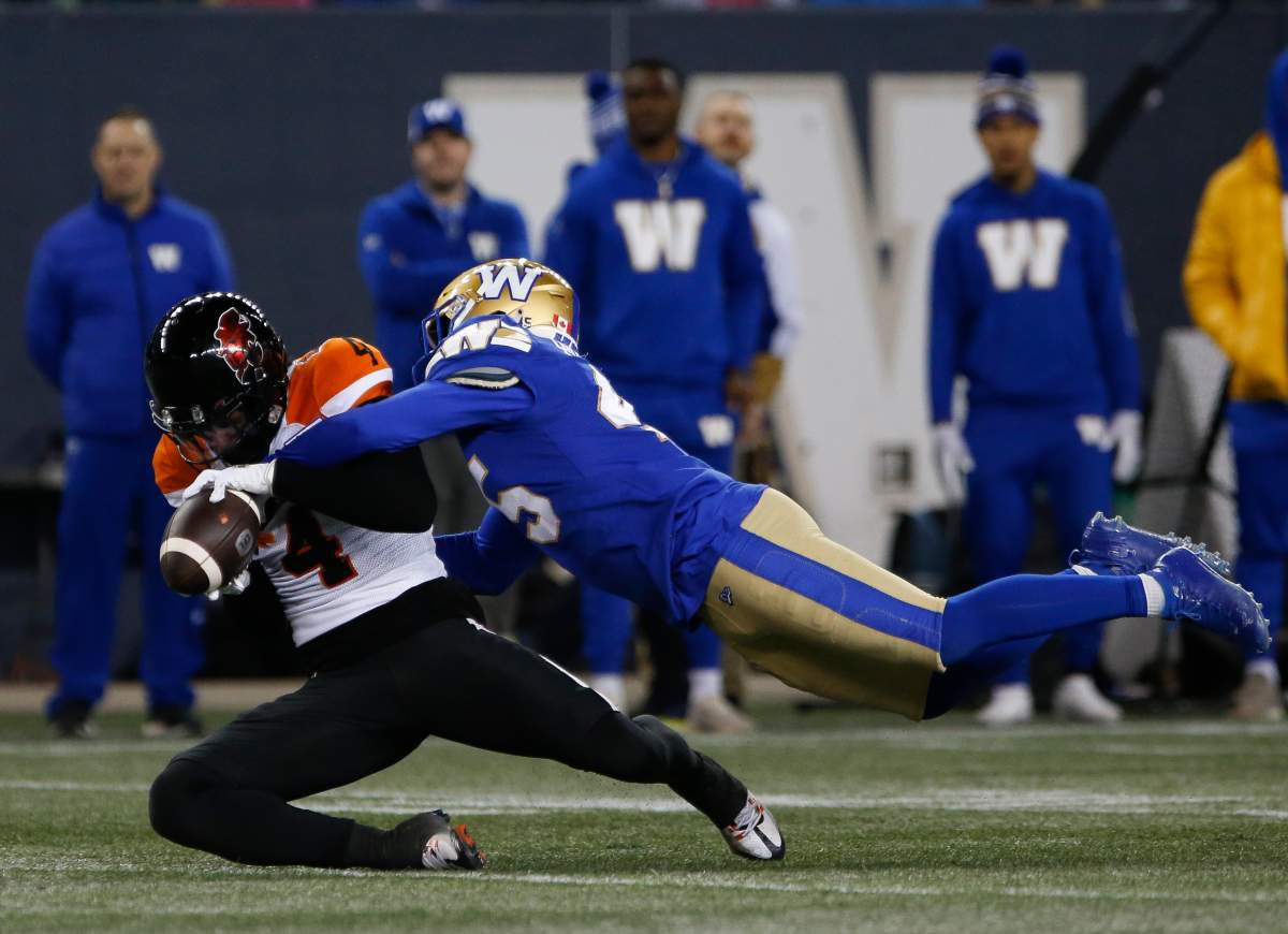 B.C. Lions' Keon Hatcher (4) hangs onto the pass against Winnipeg Blue Bombers' Jamal Parker (45) during first half CFL action in Winnipeg Friday, October 28, 2022.    THE CANADIAN PRESS/John Woods.