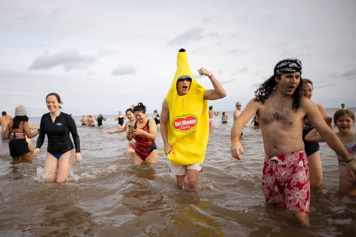 People participate in the annual polar bear dip on New Year’s Day in Oakville, Ont., Wednesday, Jan. 1, 2025. THE CANADIAN PRESS/Nick Iwanyshyn