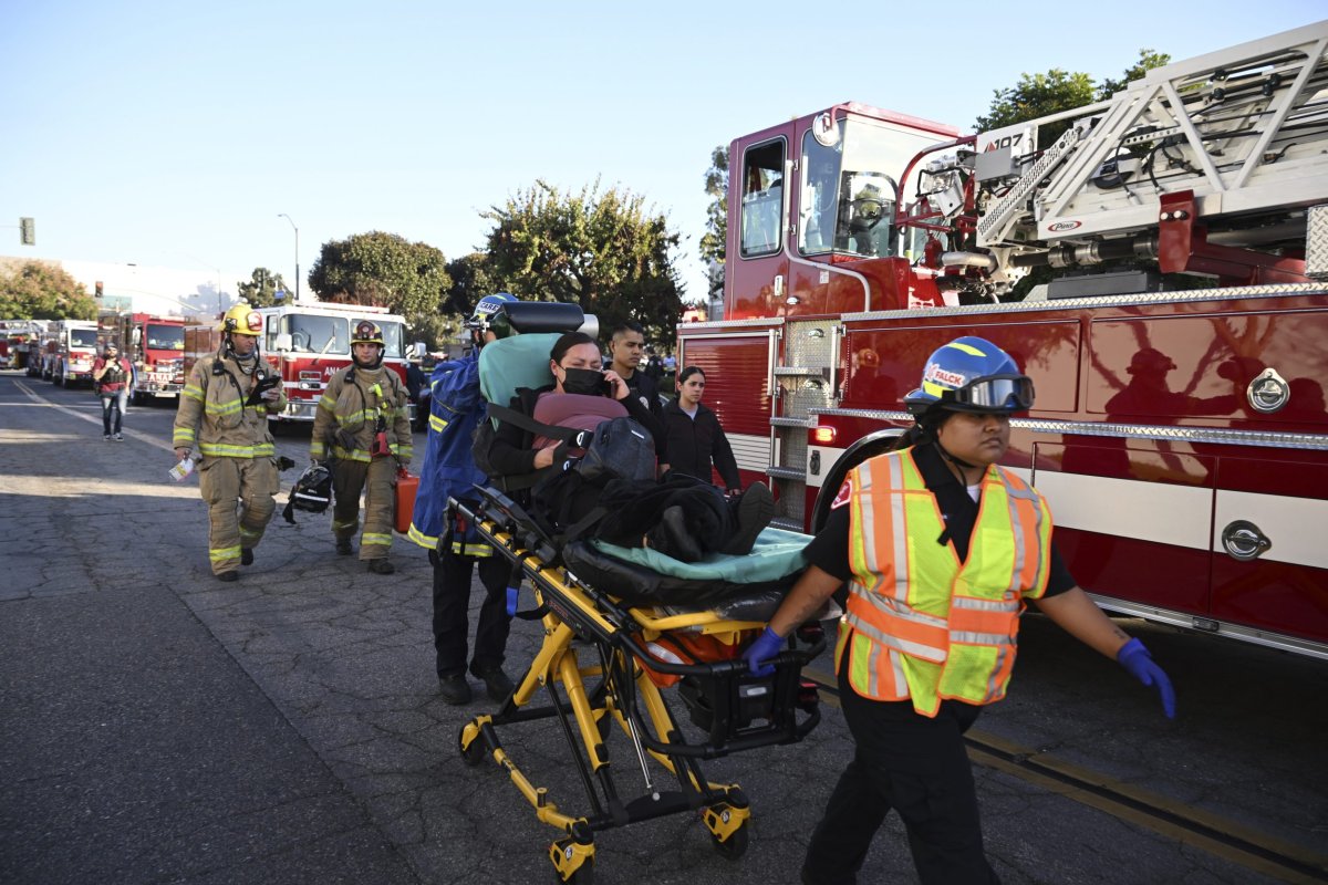 A woman is carried on a stretcher near the site of a plane crash, Thursday, Jan. 2, 2025, in Fullerton, Calif. (AP Photo/Kyusung Gong).