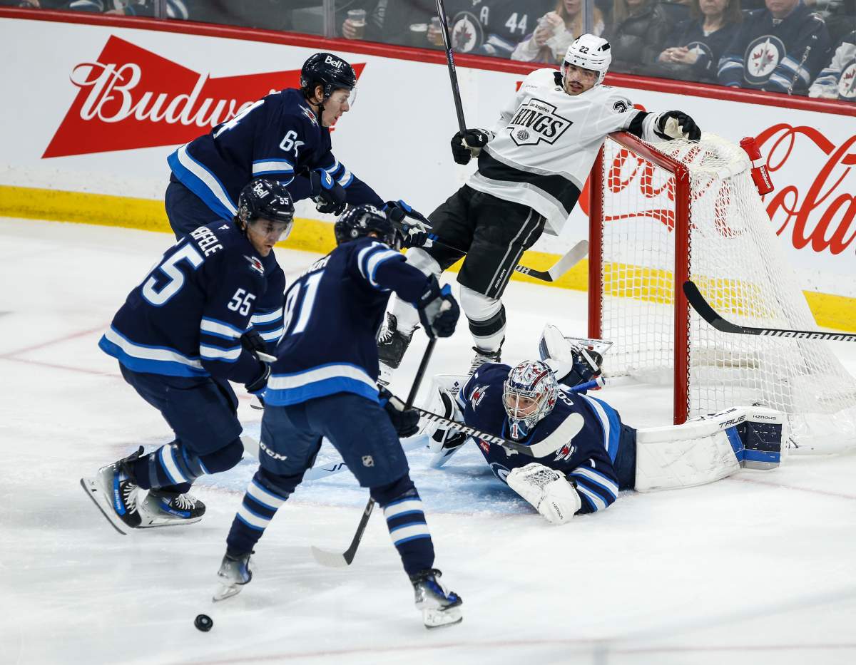 Winnipeg Jets goaltender Eric Comrie (1) keeps his eye on the rebound as Los Angeles Kings' Kevin Fiala (22) crashes into the net during first period NHL action in Winnipeg on Friday, January 10, 2025. THE CANADIAN PRESS/John Woods.