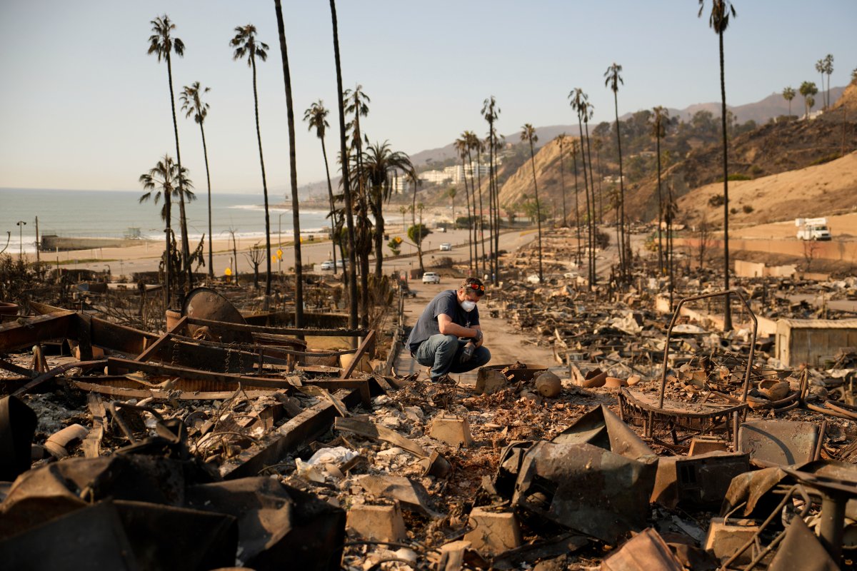 Kevin Marshall sifts through his mother's fire-ravaged property in the the Palisades Fire in the Pacific Palisades neighborhood of Los Angeles, Saturday, Jan. 11, 2025.