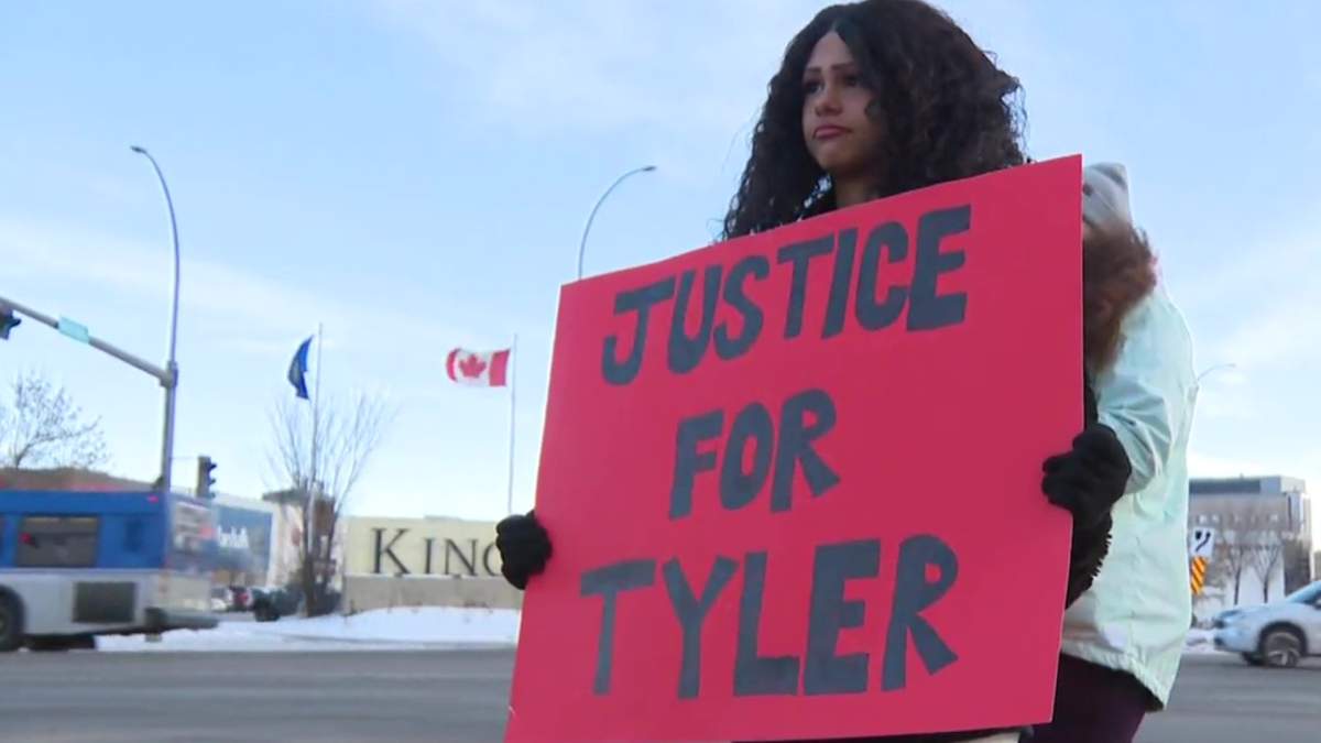 A demonstrator holding a sign calling for justice for Tyler Duboski, one of two motorcycle riders killed in a crash in northern Alberta on Aug. 31, 2024.