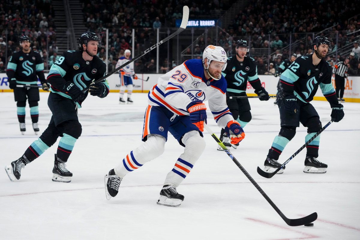 Edmonton Oilers center Leon Draisaitl (29) breaks away to score an empty net goal as Seattle Kraken left wing Jared McCann, left, and Oliver Bjorkstrand, right, watch during the third period of an NHL hockey game Saturday, Jan. 4, 2025, in Seattle.