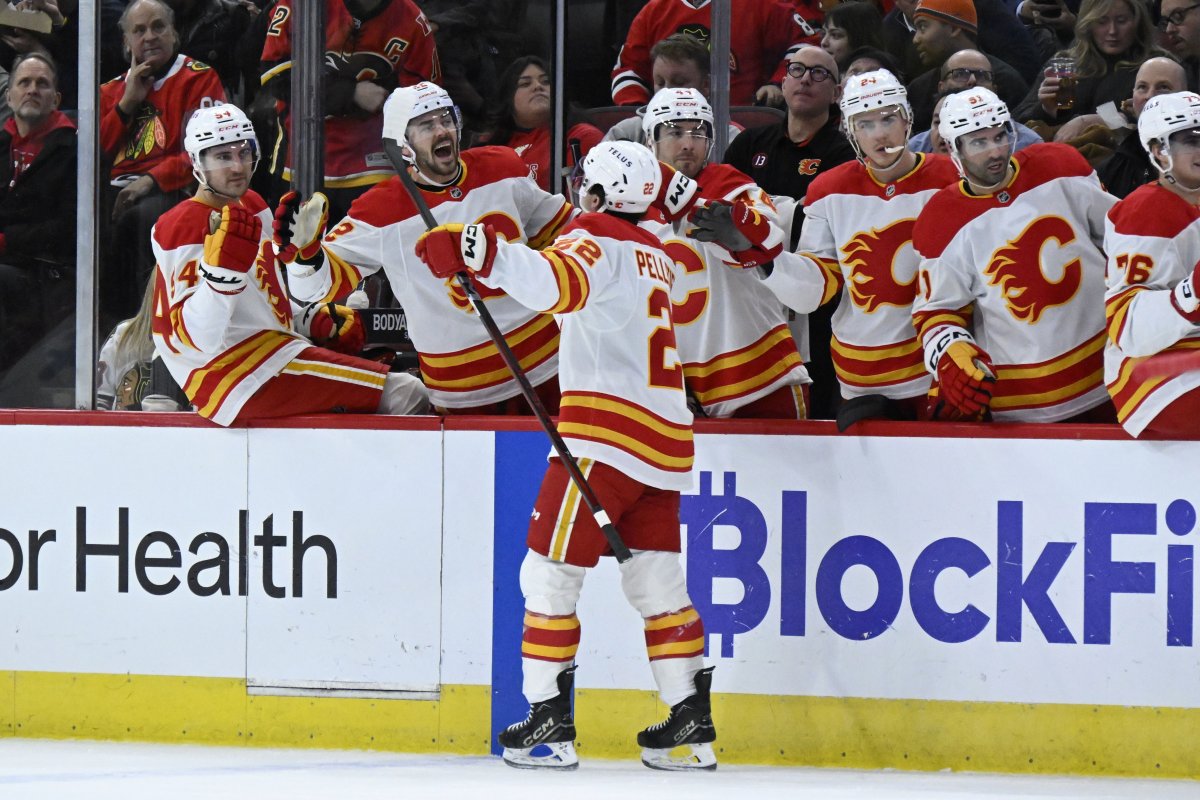 Calgary Flames left wing Jakob Pelletier (22) celebrates with teammates after scoring a goal against the Chicago Blackhawks during the first period of an NHL hockey game, Monday, Jan. 13, 2025, in Chicago.