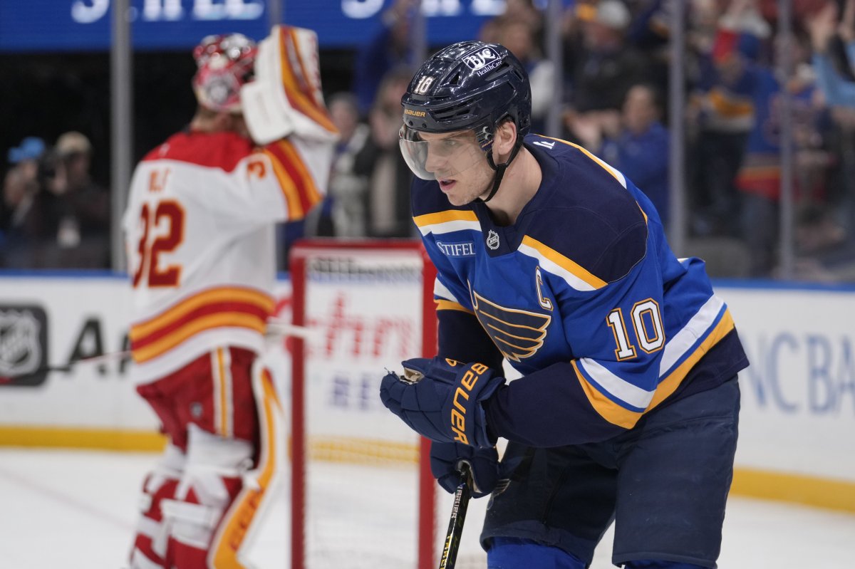 St. Louis Blues' Brayden Schenn (10) skates after scoring past Calgary Flames goaltender Dustin Wolf, left, during the second period of an NHL hockey game Thursday, Jan. 16, 2025, in St. Louis.