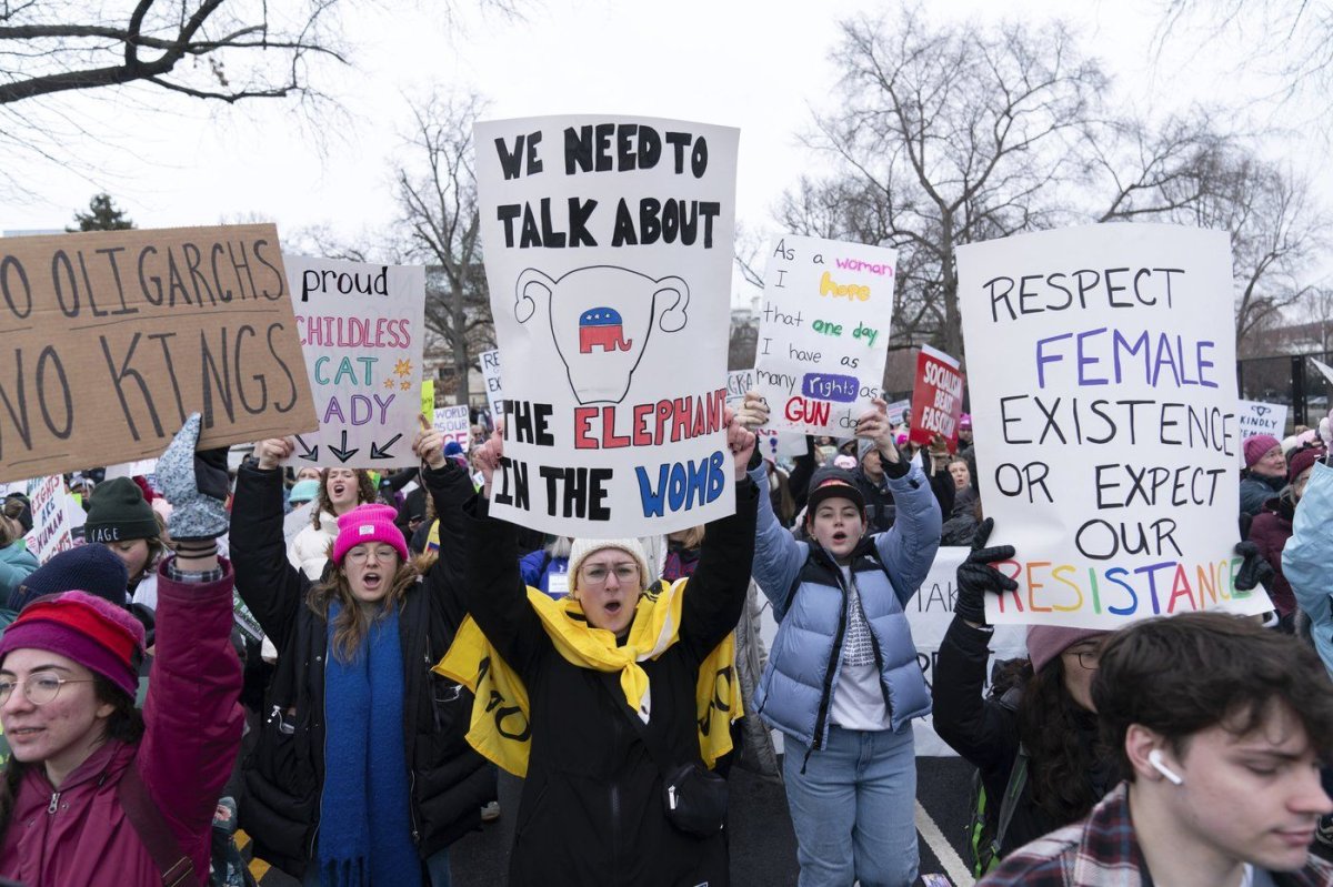 Demonstrators hold signs as they protest President-elect Donald Trump's incoming administration during the People's March, Saturday, Jan. 18, 2025, in Washington. (AP Photo/Jose Luis Magana) Jose Luis Magana