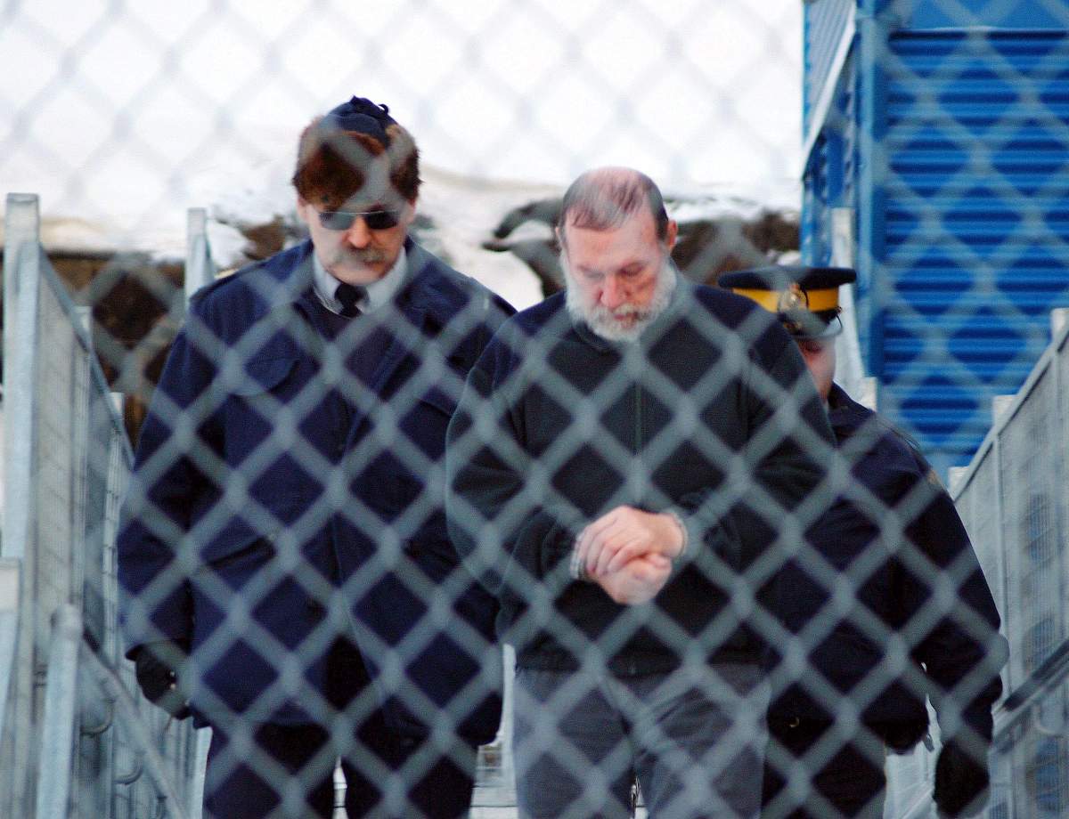Defrocked Catholic priest Eric Dejaeger is escorted by police outside an Iqaluit courtroom on Jan. 20, 2011, after his first appearance for six child sexual abuse charges in Igloolik, Nunavut, dating back to the 1970s.