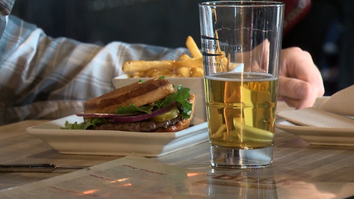 Statistics Canada says Canadian's paid less for food and alcoholic beverages purchased in restaurants last month, compared to a year earlier, and it credited the federal government's temporary break in the GST for much of the decline.