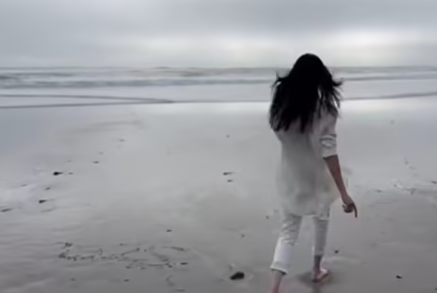 As Meghan Markle jogs toward the ocean, a previous "2025" can be seen already written in the sand.