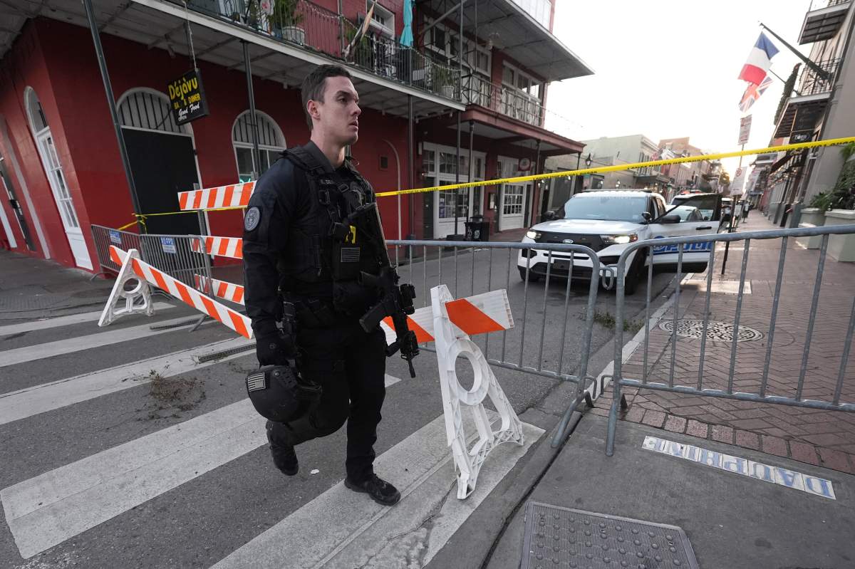 A member of the emergency services walks past a police barricade after a vehicle drove into a crowd on New Orleans’ Canal and Bourbon Street, Wednesday Jan. 1, 2025.