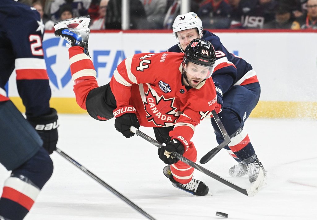Canada’s Josh Morrissey (44) is tripped by the United States’ Jake Guentzel (59) during the first period of 4 Nations Face-Off hockey action in Montreal on Feb. 15, 2025.