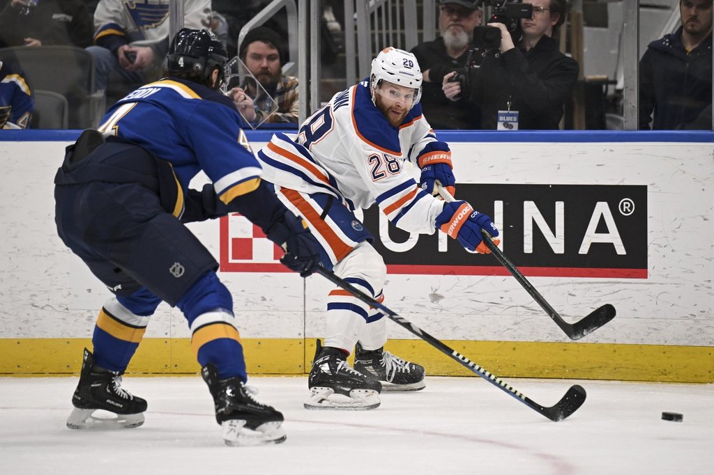 Edmonton Oilers' Connor Brown, right, passes the puck as St. Louis Blues' Nick Leddy, left, defends during the first period of an NHL hockey game Tuesday, Feb. 4, 2025, in St. Louis. (AP Photo/Connor Hamilton).