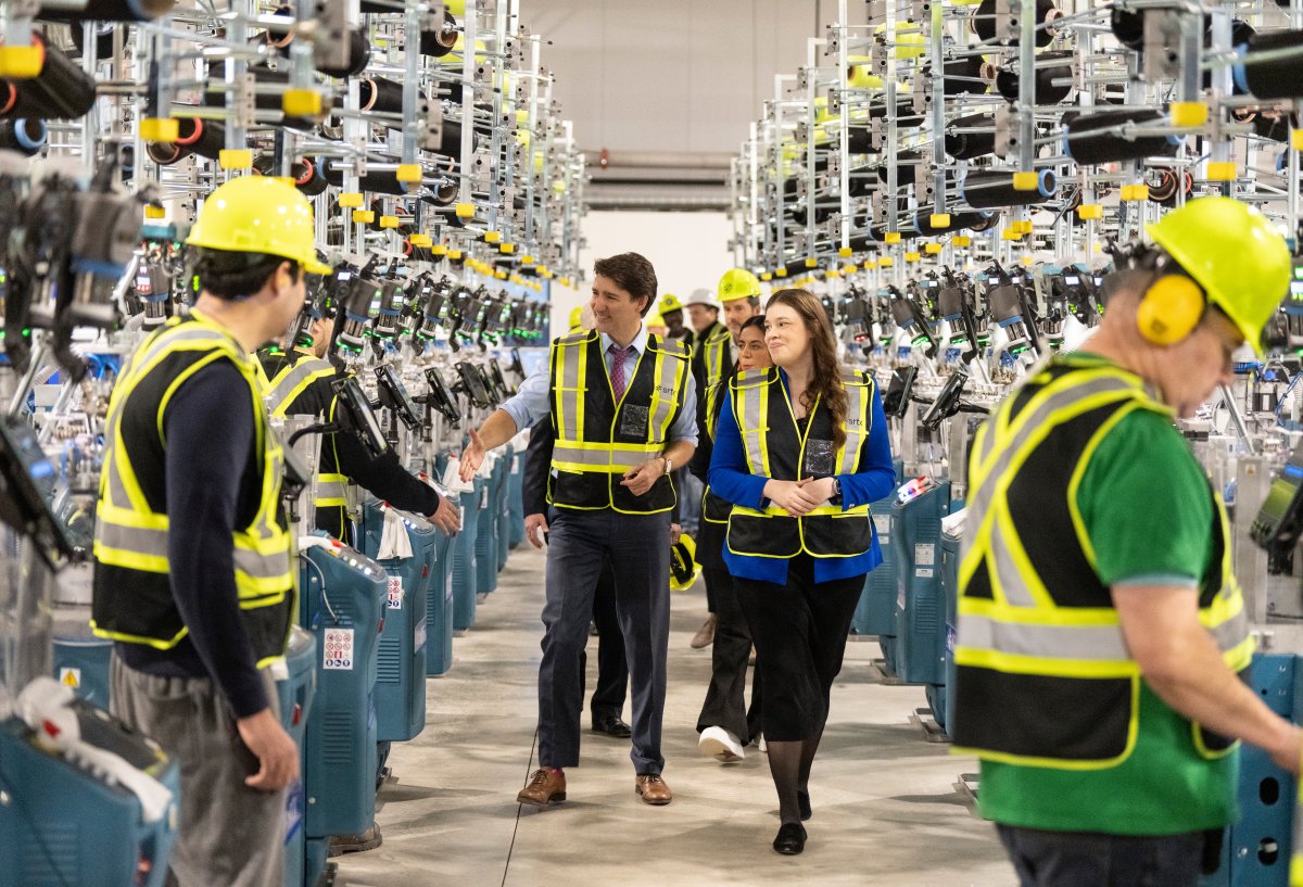 Prime Minister Justin Trudeau, centre, greets workers as he tours Sheertex, a pantyhose manufacturing plant, with founder Katherine Homuth, on International Women’s Day in Pointe-Claire, Que., Friday March 8, 2024.