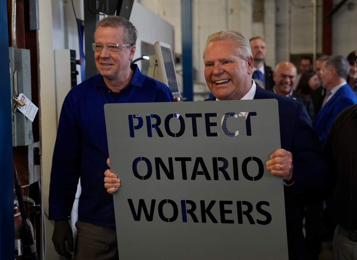 Ontario Progressive Conservative Leader Doug Ford holds a sign cut with a laser cutting machine during a visit to a company in Ottawa, Tuesday, Feb.4, 2025.