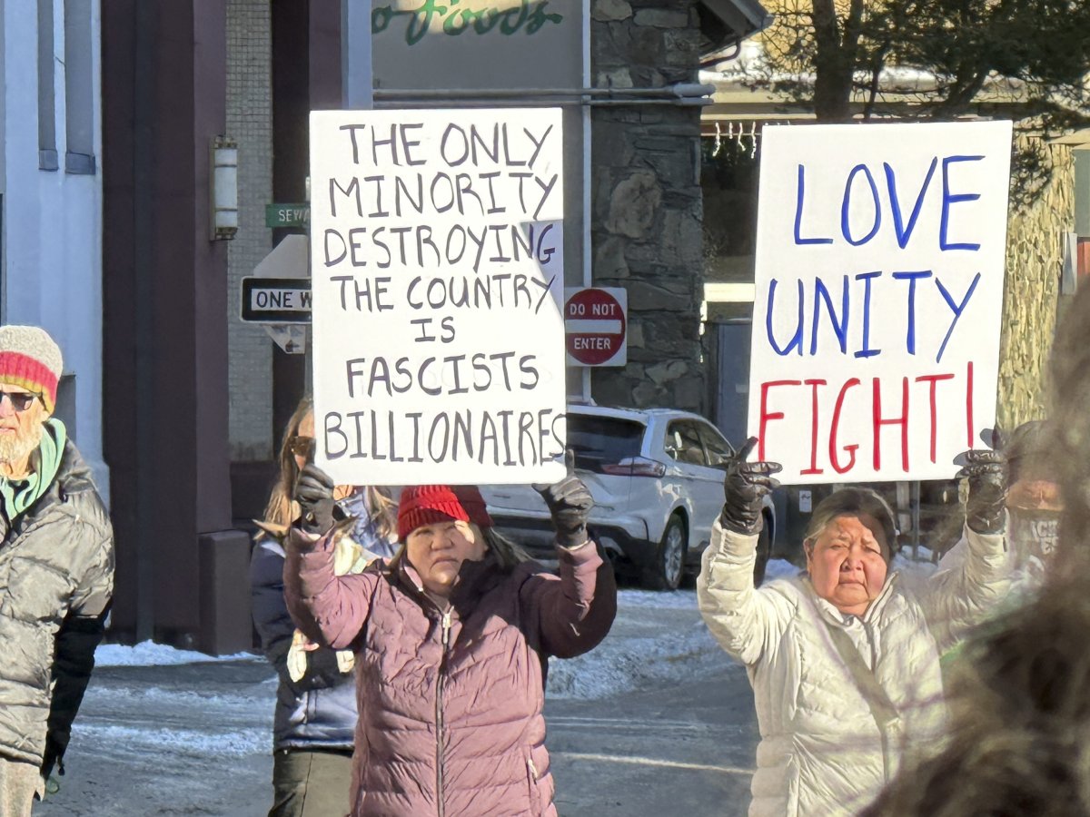 People hold signs as part of a protest against the Trump administration and Project 2025 in Juneau, Alaska, on Wednesday, Feb. 5, 2025.