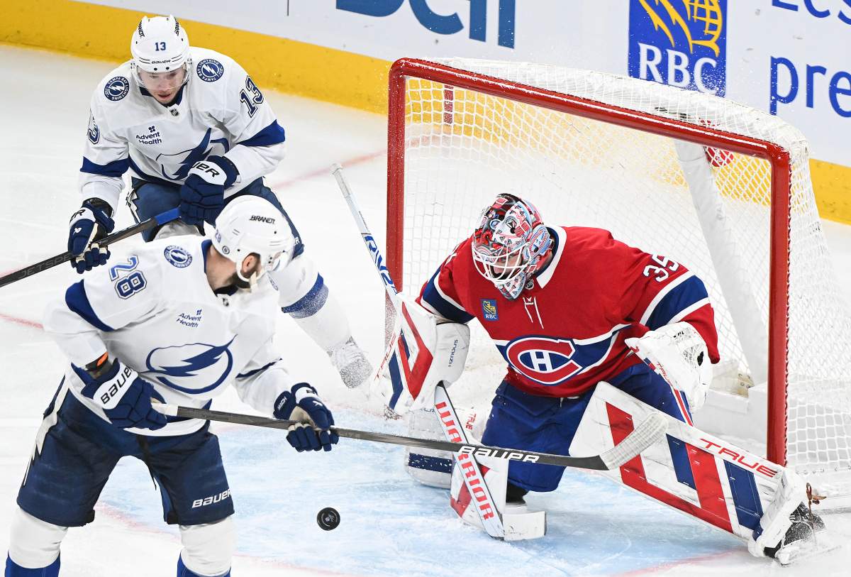Tampa Bay Lightning's Zemgus Girgensons (28) and Cam Atkinson (13) move in on Montreal Canadiens goaltender Sam Montembeault during third period NHL hockey action in Montreal, Sunday, Feb. 9, 2025.