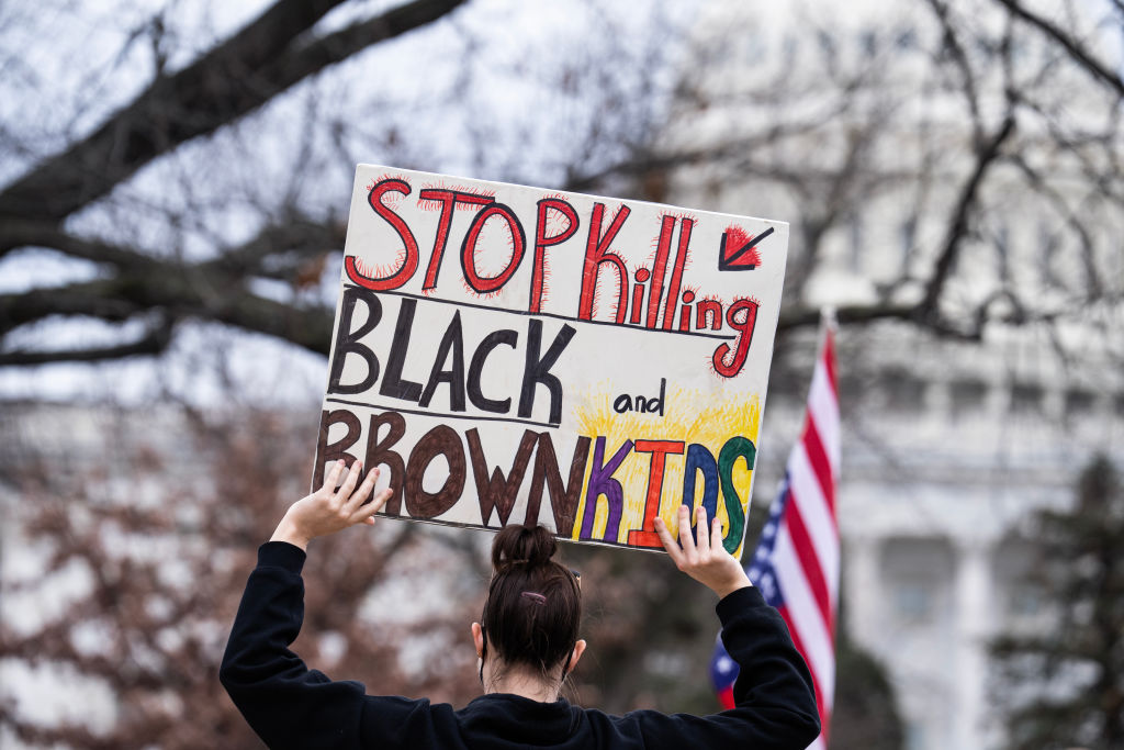 A demonstrator holds a sign at a rally in Upper Senate Park in response to the disruption of USAID to demand that congress and President Trump act to restore foreign aid, on Wednesday, Feb. 5, 2025.