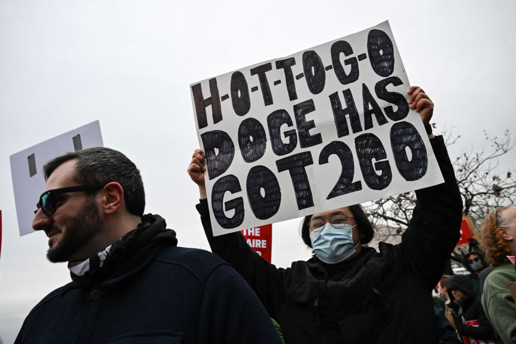 A person holds up a sign as they protest against President Donald Trump and Elon Musk's "Department of Government Efficiency" (DOGE) outside of the US Department of Labor near the US Capitol in Washington, D.C., Feb. 5, 2025.