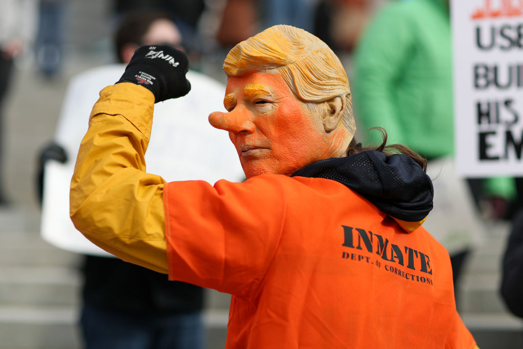 A protester wears a Trump mask and an orange jumpsuit during a 50501 protest outside of the Pennsylvania Capitol on Feb. 5, 2025.