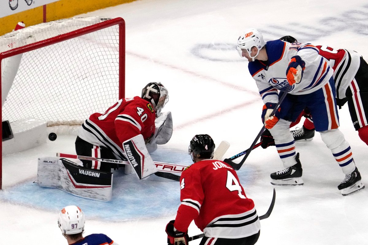 Edmonton Oilers left wing Zach Hyman, right, scores the game-winning goal against Chicago Blackhawks goaltender Arvid Soderblom during an overtime period of an NHL hockey game in Chicago, Wednesday, Feb. 5, 2025.