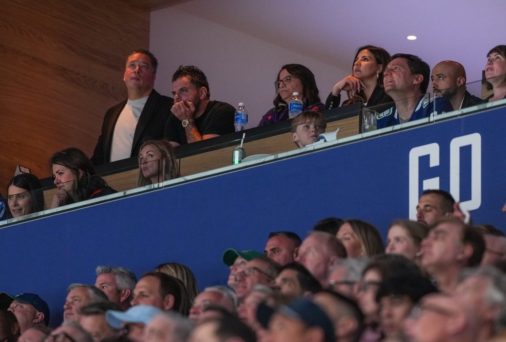 Alberta Premier Danielle Smith, front second left, and B.C. Premier David Eby, front right, watch the Vancouver Canucks and Edmonton Oilers play Game 2 of an NHL hockey Stanley Cup second-round playoff series in Vancouver on May 10, 2024.