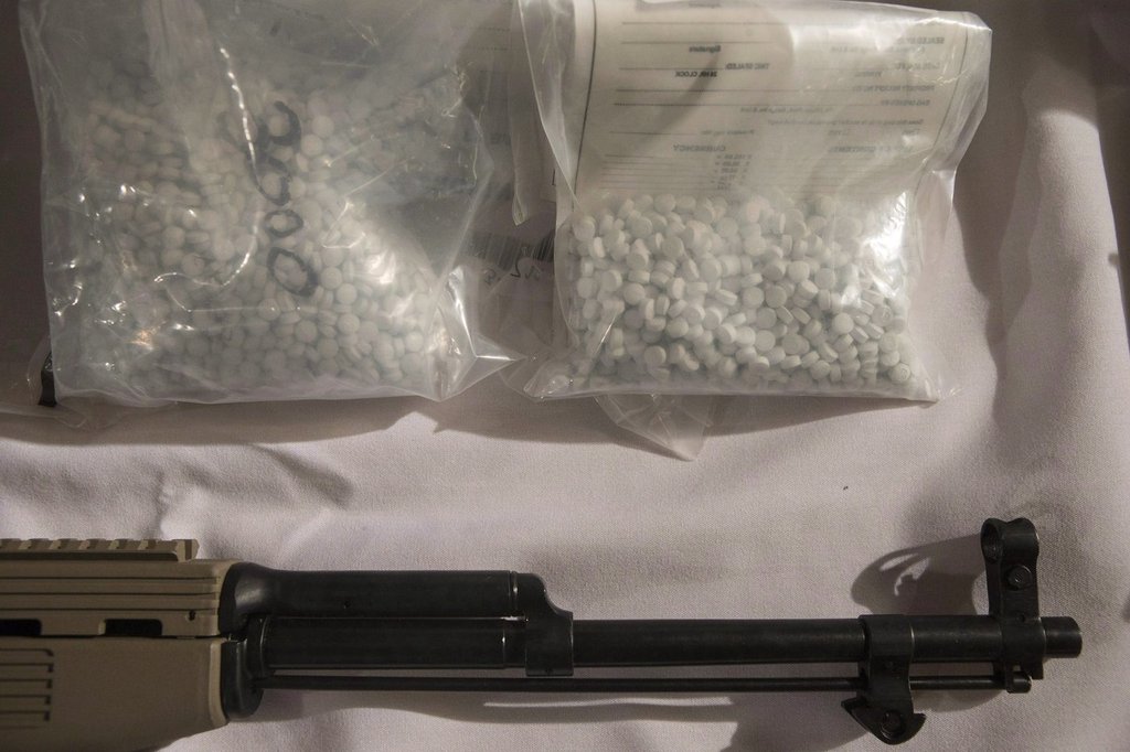 Bags containing fentanyl lie next to a firearm at a police news conference in Vaughan, Ont., on Thursday, Feb. 23, 2017. THE CANADIAN PRESS/Chris Young.