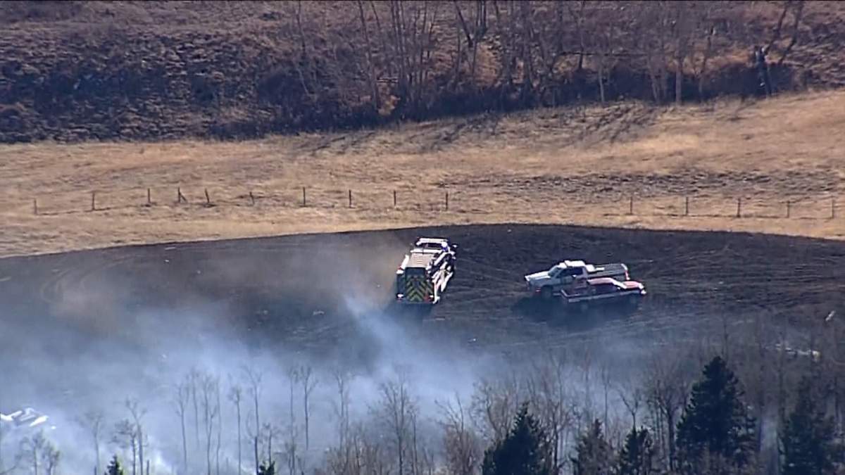Firefighters were seen attacking a rapidly spreading grass fire from both the ground and the air after it broke out west of Cochrane on Tuesday afternoon.