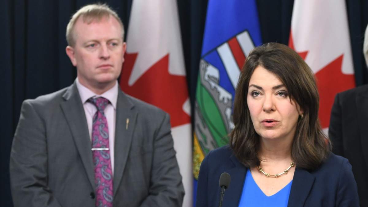  Martin Long stands behind Premier Danielle Smith at a news conference in Edmonton on Wednesday, November 22, 2023.
