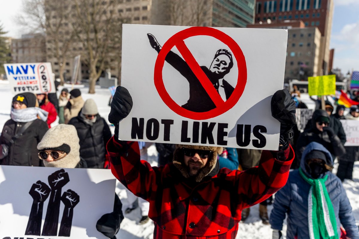 A protester holds up a sign as more than 700 people gathered at the steps of Michigan's Capitol to protest the second administration of President Donald Trump, Monday, Feb. 17, 2025 on Presidents' Day in Lansing.