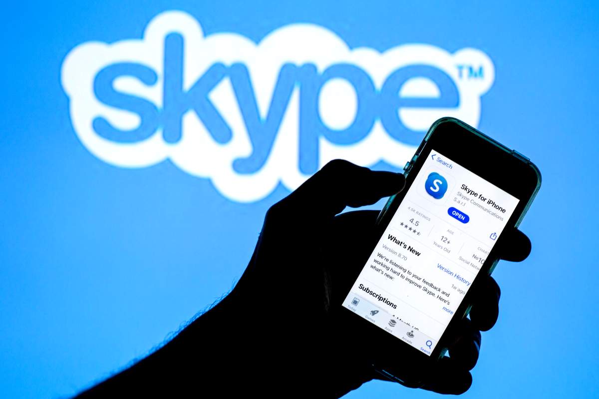 SPAIN - 2021/04/20: In this photo illustration, a Skype app in App Store seen displayed on a smartphone with the Skype logo in the background.