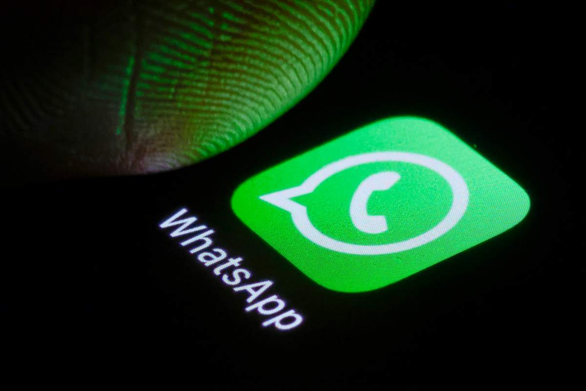 Photo illustration the logo of WhatsApp can be seen next to a finger on a smartphone on January 03, 2025 in Berlin, Germany. 