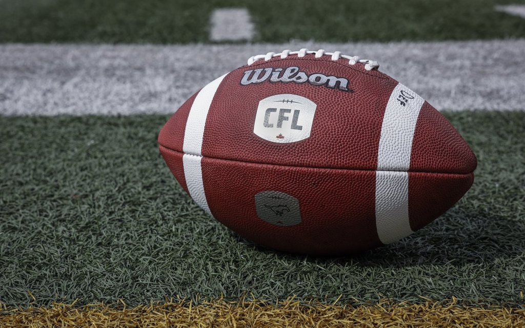 A football sits on the sidelines as the Calgary Stampeders run drills during opening day of training camp in Calgary, Alta., Sunday, May 12, 2024.
