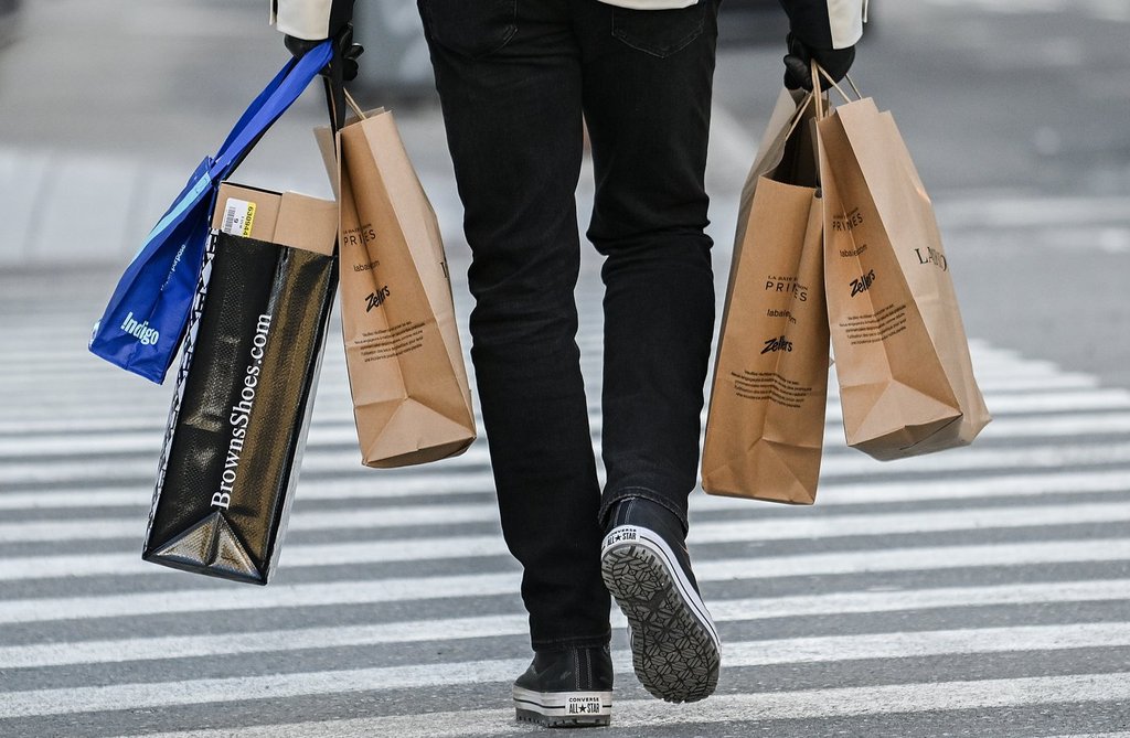 A person carries shopping bags along a street in Montreal, Saturday, Dec. 14, 2024.