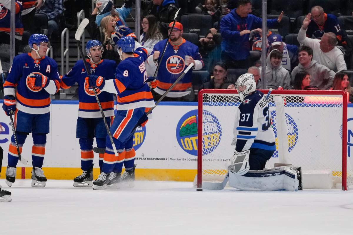Winnipeg Jets goaltender Connor Hellebuyck (37) reacts as the New York Islanders celebrate a goal by Kyle Palmieri during the first period of an NHL hockey game Tuesday, March 4, 2025, in Elmont, N.Y. (AP Photo/Frank Franklin II).