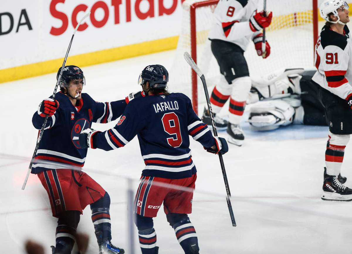Winnipeg Jets' Alex Iafallo (9) and Mark Scheifele (55) celebrates Iafallo's goal against the New Jersey Devils during first period NHL action in Winnipeg on Friday, March 28, 2025. THE CANADIAN PRESS/John Woods.