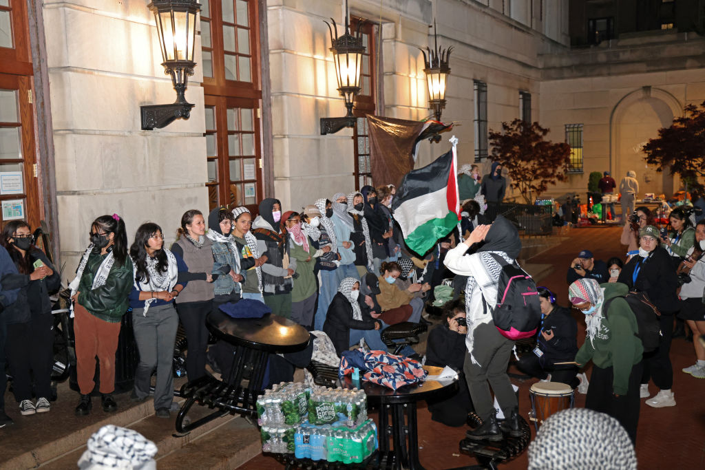 Pro-Palestinian student protesters lock arms at the entrance to Hamilton Hall on the campus of Columbia University, on April 30, 2024, in New York City. Dozens of helmeted police flooded Columbia University's campus in the heart of New York City on April 30, 2024 to evict a building occupied by pro-Palestinian student protesters and detain demonstrators. Police climbed into Hamilton Hall via a second floor window they reached from a laddered truck, before leading handcuffed students out of the building into police vans. (Photo by Jia Wu / AFP) (Photo by JIA WU/AFP via Getty Images)
