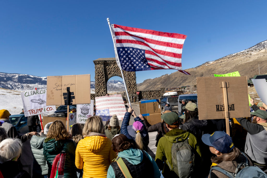 Protesters hold signs at Roosevelt Arch, the northern entrance to Yellowstone Park on March 1, 2025 in Gardiner, Montana. About 200 people showed up at the rally to protest recent firings of the National Park Service and National Forest Service Staff. Similar protests were held at many other national parks throughout the United States.