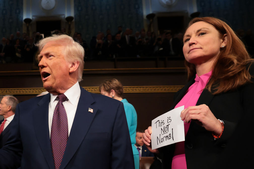 As U.S. President Donald Trump arrives for his speech to a joint session of Congress as Rep. Melanie Stansbury (D-NM) holds a sign reading "This is not normal" at the U.S. Capitol. (Photo by Win McNamee/Getty Images)