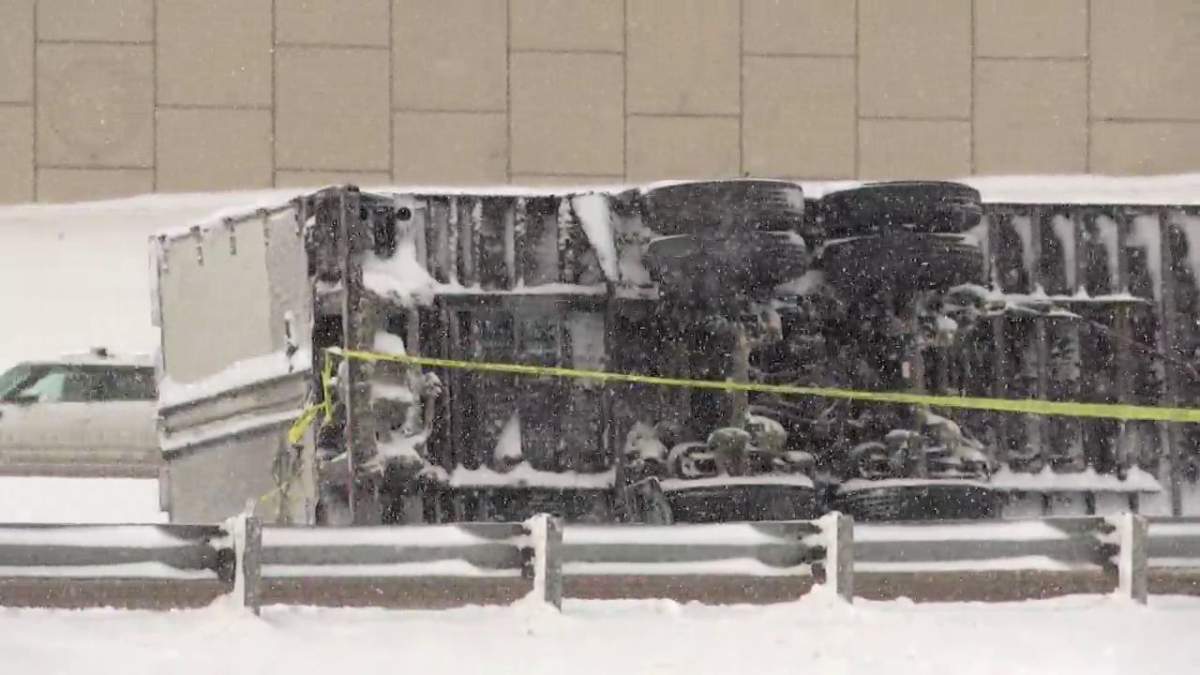 A semi-truck is seen lying on its side by an Edmonton area road on March 28, 2025. Police warned that heavy snowfall had led to poor road conditions in the region.