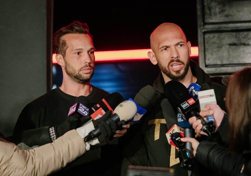 Andrew Tate and his brother Tristan Tate talk to the media outside their residence on March 23, 2025 in Bucharest, Romania.