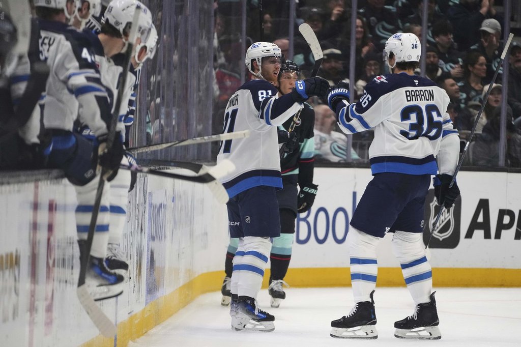 Winnipeg Jets left wing Kyle Connor (81) is greeted by centre Morgan Barron (36) after scoring against the Seattle Kraken during the second period of an NHL hockey game Sunday, March 16, 2025, in Seattle.
