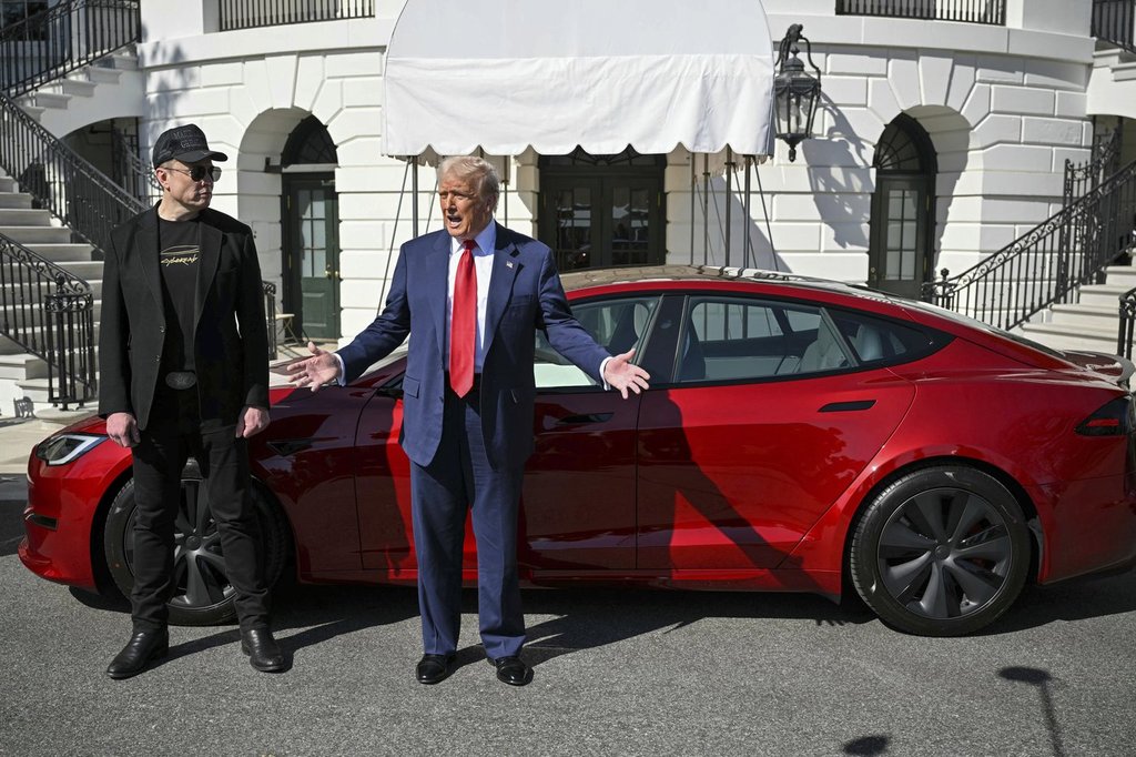 President Donald Trump and Tesla CEO Elon Musk speak to reporters near a red Model S Tesla vehicle on the South Lawn of the White House Tuesday, March 11, 2025, in Washington.