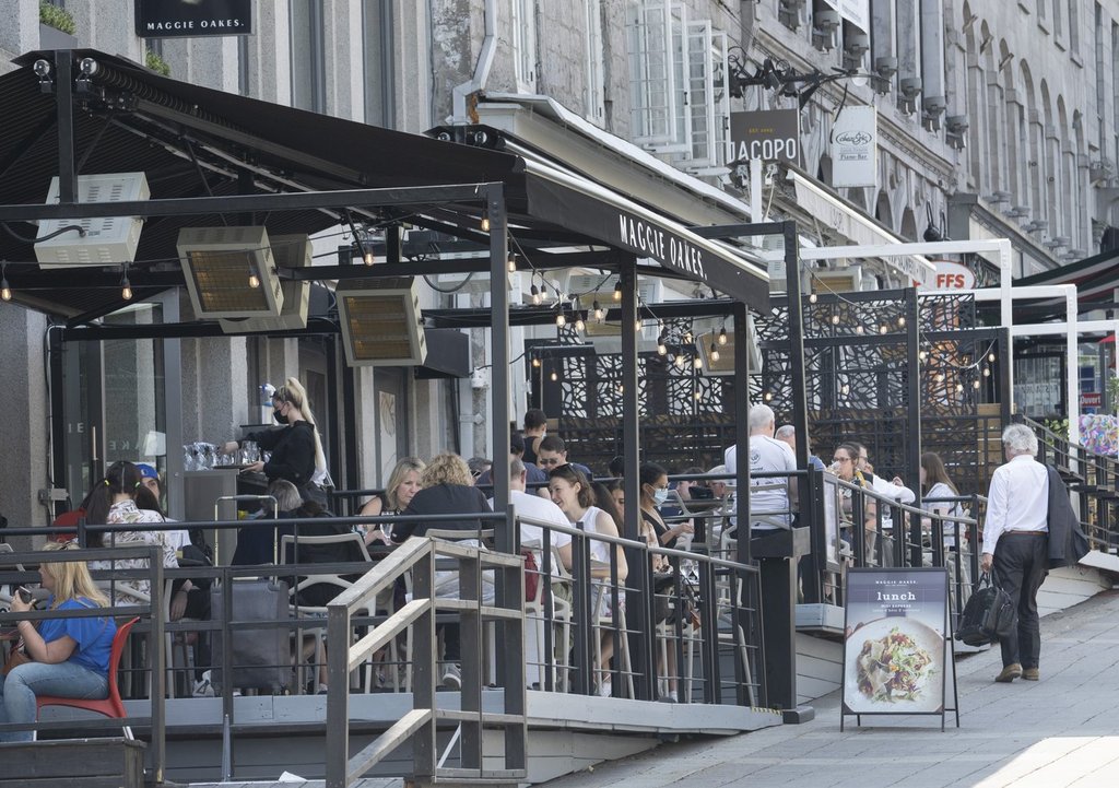 People enjoy the warm weather and dine on a terrace in Montreal, Thursday, May 12, 2022. The Quebec government says it's drafting a bill to allow restaurants to charge people who reserve a table but don't show up and don't cancel ahead of time. 