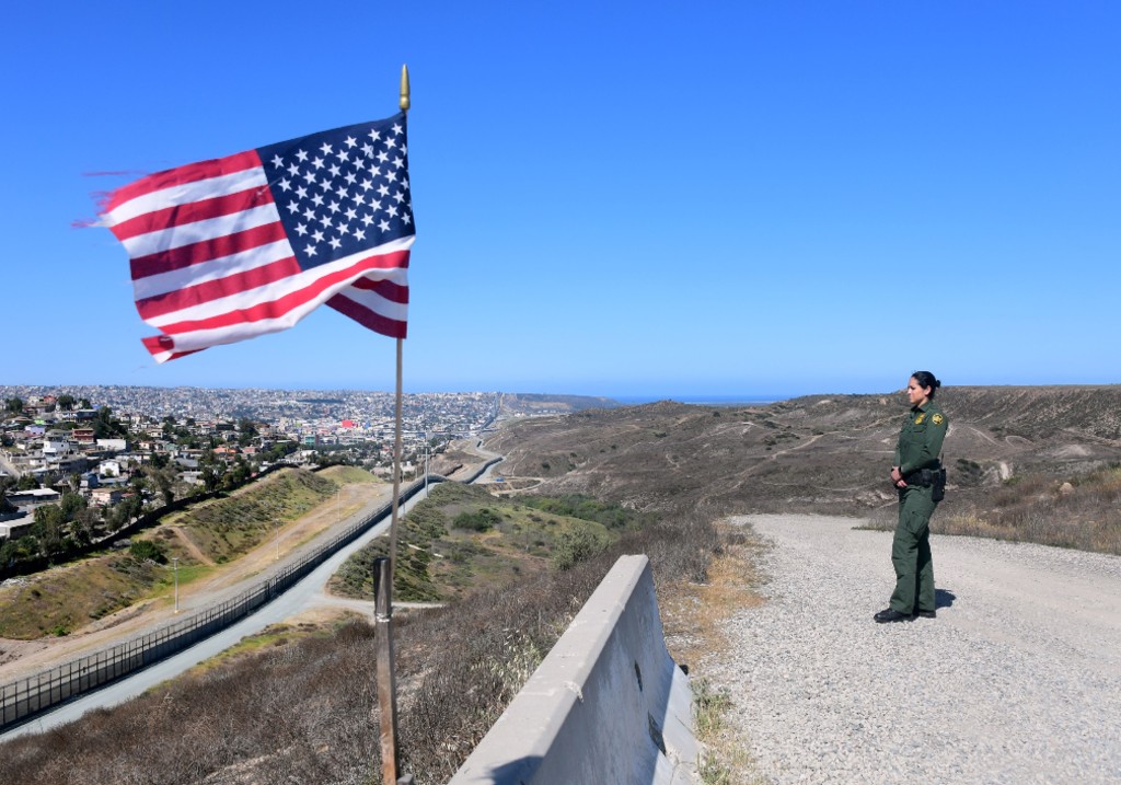 A file photo of US Customs and Border Protection agent Tekae Michael stands at a lookout point overlooking the Border Infrastructure System, a no man's land area between the wall and fence which runs for 14 miles in land from the Pacific Ocean separating California from Mexico on April 17, 2018 in San Diego, California across from Tijuana, Mexico, a day after California rejected plans by the federal government for National Guard troops on the border.