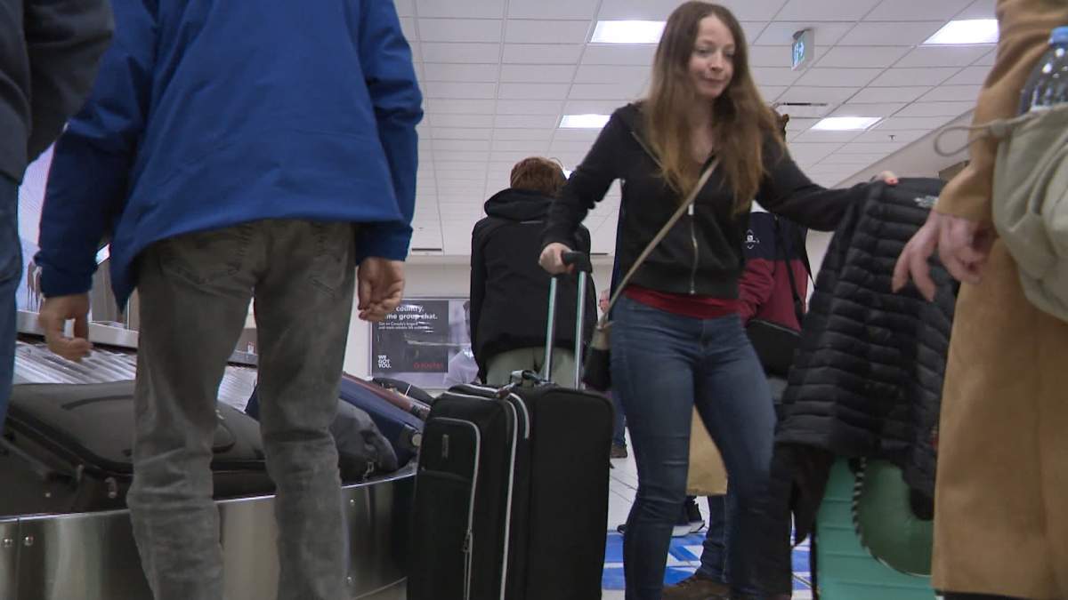 Passengers on a Westjet flight from Calgary to Ottawa are seen collecting their bags after being told their flight was cancelled on Wednesday because of a security incident.